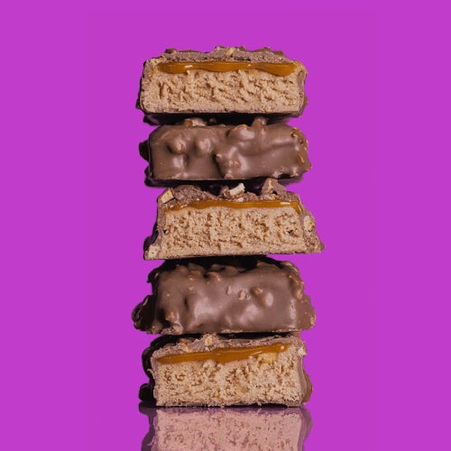 unwrapped stack of fulfil bars with peanut caramel drizzle pouring down on them